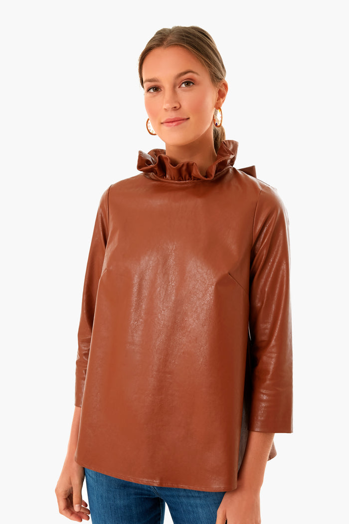 Model wearing a classic, high-end, brown faux-leather top with a ruffled collar, perfectly paired with Pearl Multi Goldie Earrings, showcasing effortless, fun style with pearls and stones.