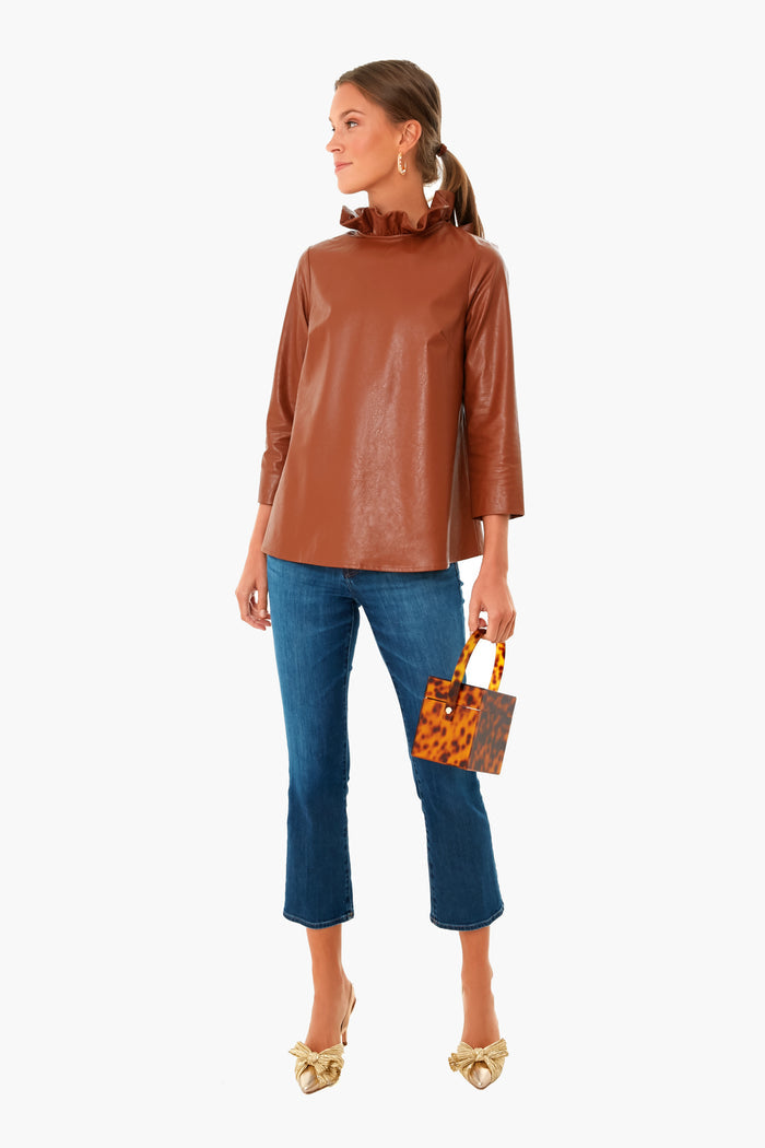 Model wears classic, glossy faux-leather blouse with jeans, paired with Pearl Multi Goldie Earrings featuring pearls and stones, embodying an effortless, high-end, and fun Tuckernuck style.