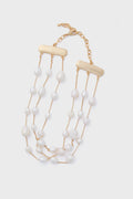 The Cult Gaia Nyala Choker is a gold chain necklace with three strands of irregular freshwater pearls and rectangular gold bars, finished with an adjustable clasp. Discover unique accessories that elevate any look.