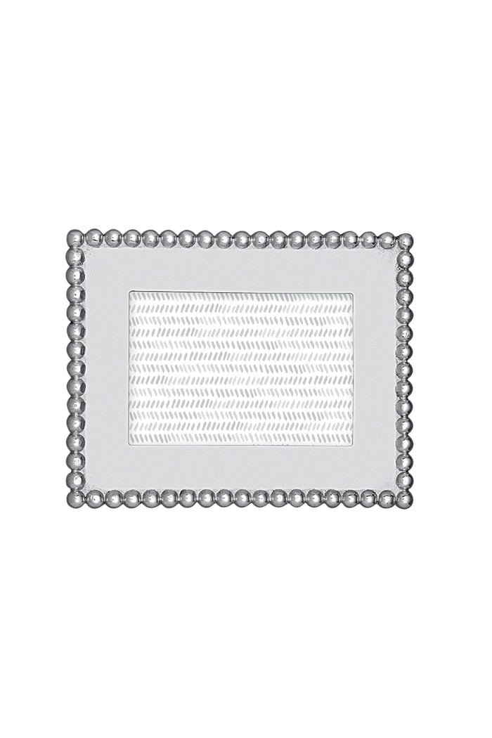 The Mariposa rectangular silver recycled aluminum frame features a beaded border and textured inner section, handcrafted for 4x6 photos—an ideal housewarming gift.