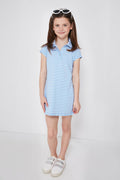 A young girl with brown hair in pigtails wears a Renwick blue and white striped girls' polo dress made from performance fabric, paired with white sneakers and white sunglasses on her head.