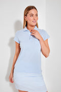 A woman wearing a light blue and white striped Renwick pima cotton polo dress looks to the side. This classic polo shirt dress is a staple in women's golf apparel.