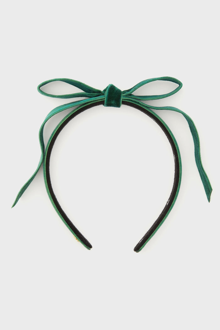 The Lele Sadoughi green velvet headband showcases a slim design with a tied bow on top and knotted detail, creating an elegant look.