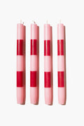 Four FAZEEK hand-painted pink dinner candles with horizontal red stripes are arranged in a row, adding a stylish touch to any table setting.