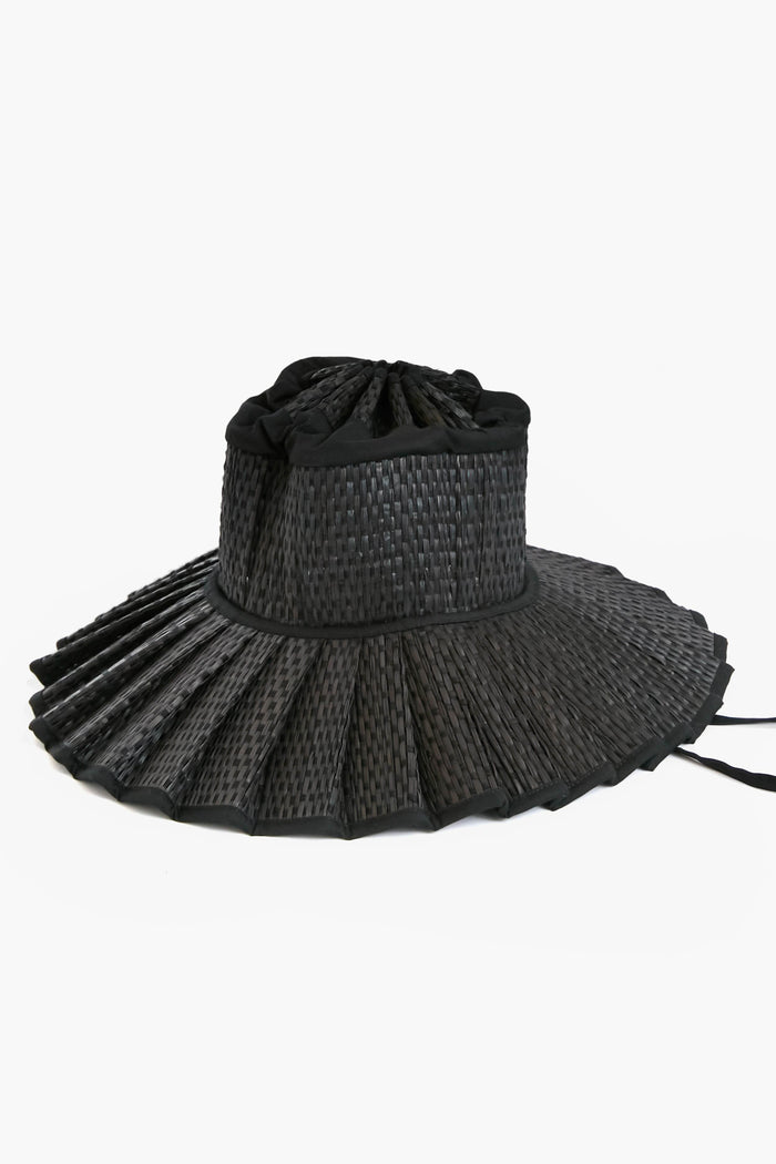 Lorna Murray's black Capri Hat features a pleated woven brim and fabric crown, blending sustainable fashion with UPF 50+ sun protection.