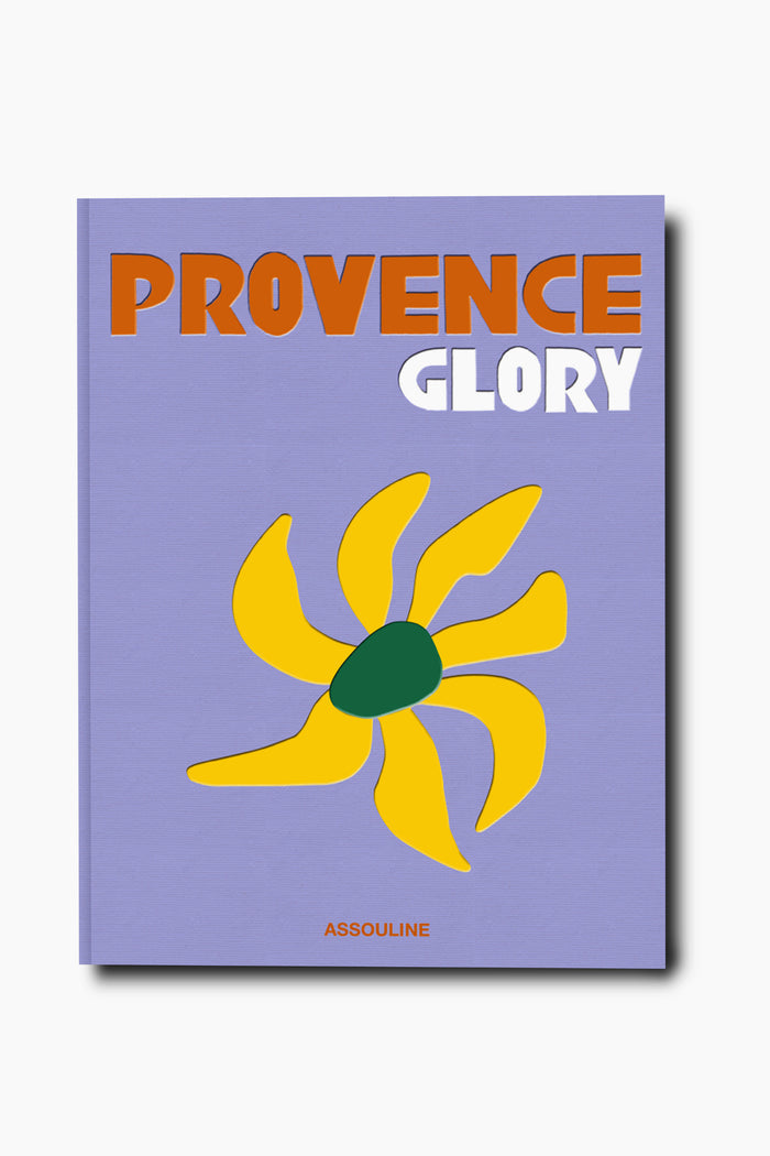 A lavender book cover titled "Provence Glory" by Assouline evokes the charm of Provence with a stylized yellow flower, green center, and the brand name at the bottom, inspired by the region’s iconic lavender fields.