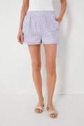 A person in light purple Steve Madden women's pull-on shorts, a white textured top, and woven slide sandals embodies effortless summer style.
