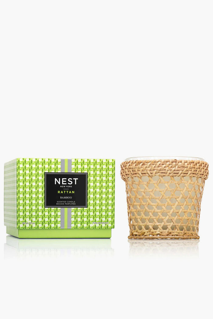 A green patterned NEST New York Bamboo Scented Candle box is next to the Bamboo 3 Wick Candle in a woven rattan holder, creating an elegant home fragrance display.