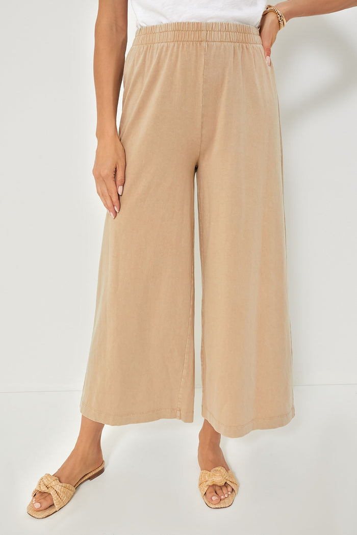 A person stands confidently in Z SUPPLY beige cotton pull-on wide-leg cropped pants, a white top, and woven sandals.