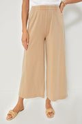 A person stands confidently in Z SUPPLY beige cotton pull-on wide-leg cropped pants, a white top, and woven sandals.
