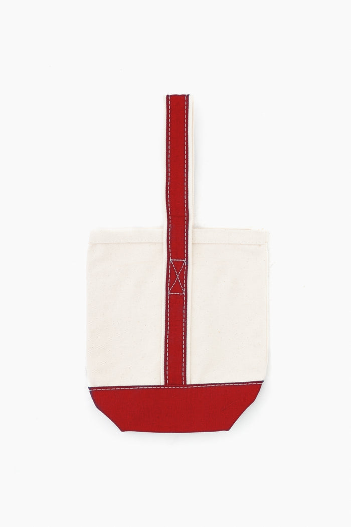 The CB Station small canvas tote bag features a plain cream body with a red base and handle, white stitching, and is made from natural materials—an eco-friendly choice for gifts or daily use.