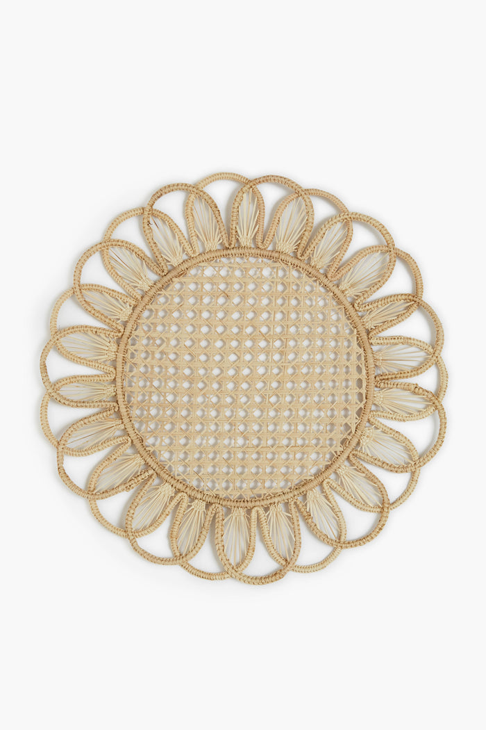 Expertly crafted by Coro Cora, this round woven Iraca palm placemat features a floral-inspired scalloped edge and an open lattice center, showcasing the artistry of Colombian accessories.