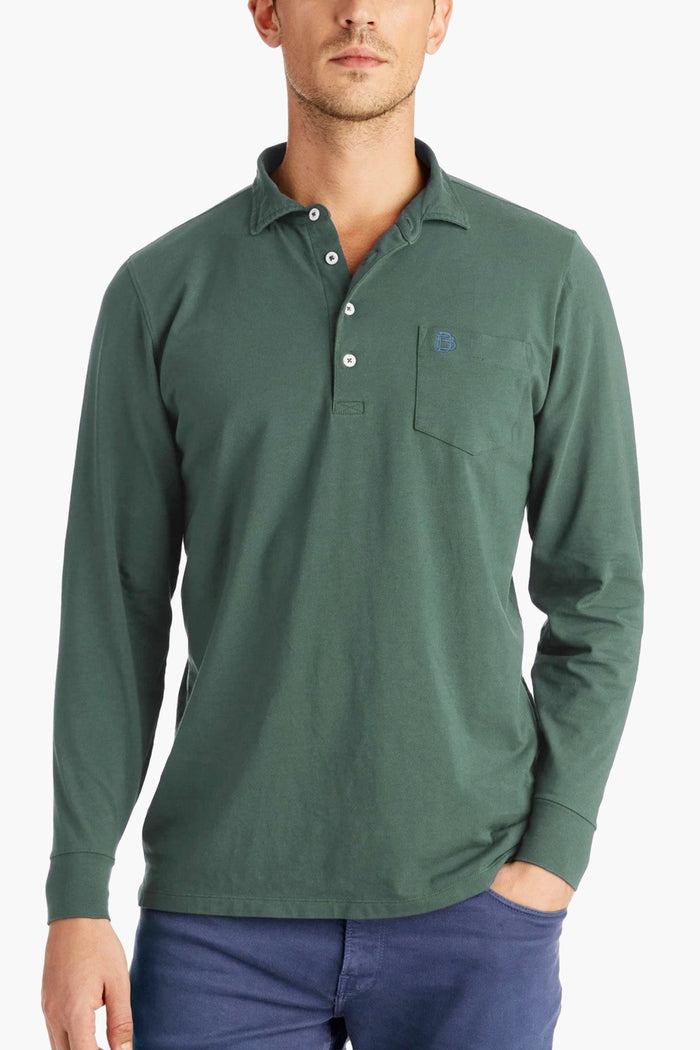 A man wears a B Draddy Peruvian Pima cotton long sleeve polo with a chest pocket and blue buttons, paired with blue pants.