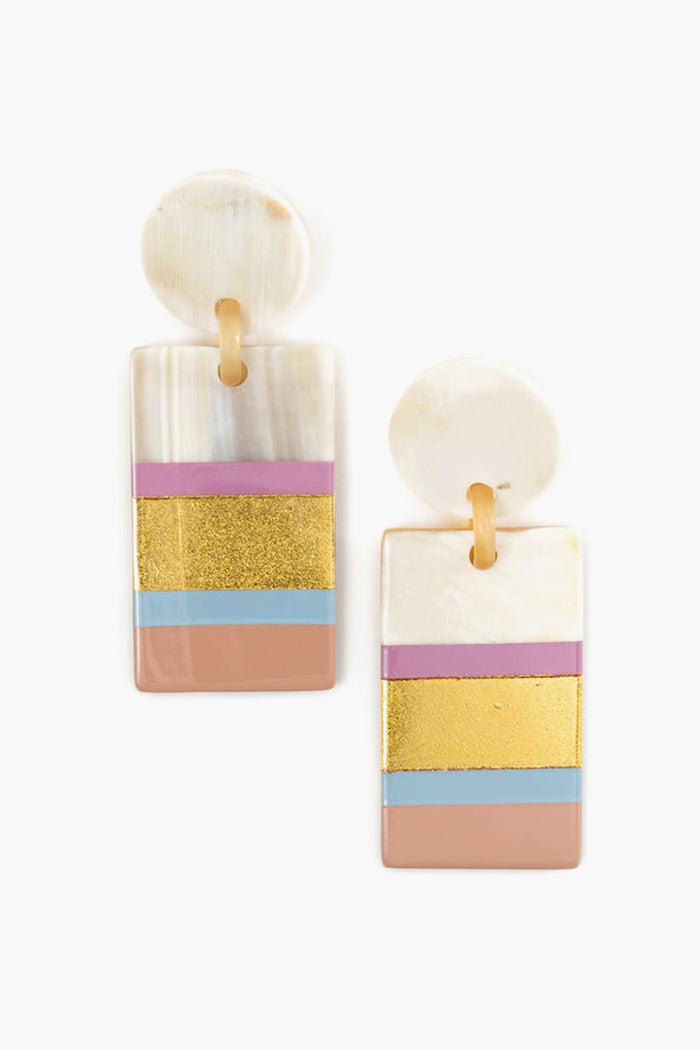 Sunshine Tienda's lightweight rectangular drop earrings feature a round stud and hand-painted horizontal pink, gold, blue, and beige stripes on a pearly white base. Ethically crafted from horn for unique jewelry artistry.