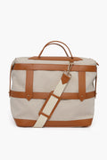 The Paravel beige canvas weekender bag features tan leather straps, accents, and handles plus a detachable cream and tan shoulder strap—an ideal sustainable travel companion for eco-conscious journeys.