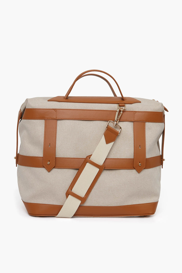 The Paravel beige canvas weekender bag features tan leather straps, accents, and handles plus a detachable cream and tan shoulder strap—an ideal sustainable travel companion for eco-conscious journeys.