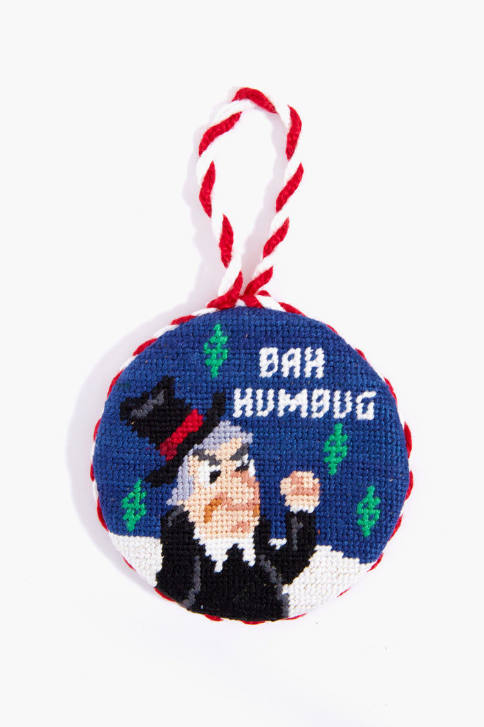 Smathers and Branson round needlepoint ornament with hand-stitched embroidery of a scowling man in a top hat, green accents, and “BAH HUMBUG”—a unique holiday decor piece.