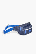 The Paravel belt bag features a navy blue design with a white stripe and blue accents, a zippered main compartment, and an adjustable strap with a plastic buckle.