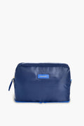 A blue rectangular zippered toiletry bag by Paravel, featuring a small front label—ideal for use as a travel organizer.
