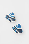 Sunshine Tienda offers lightweight earrings crafted from buffalo horn, featuring two semi-circular shapes adorned with blue, black, and white geometric patterns for a unique look.