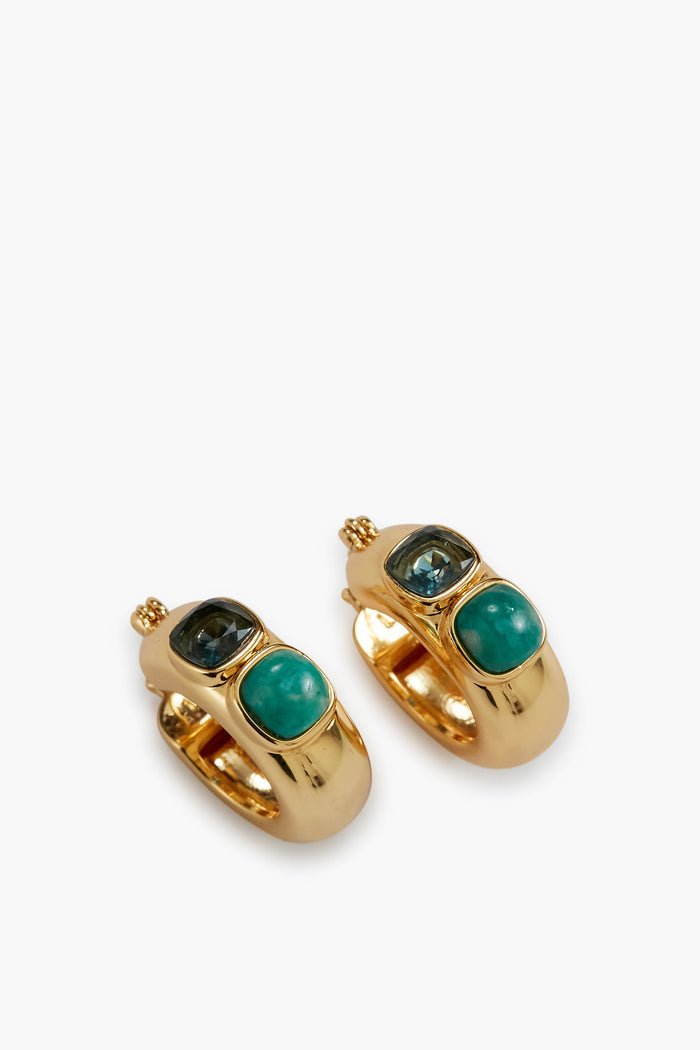 Gold-plated hoop earrings by Lizzie Fortunato, each featuring a geometric inlay with one green and one blue oval gemstone.