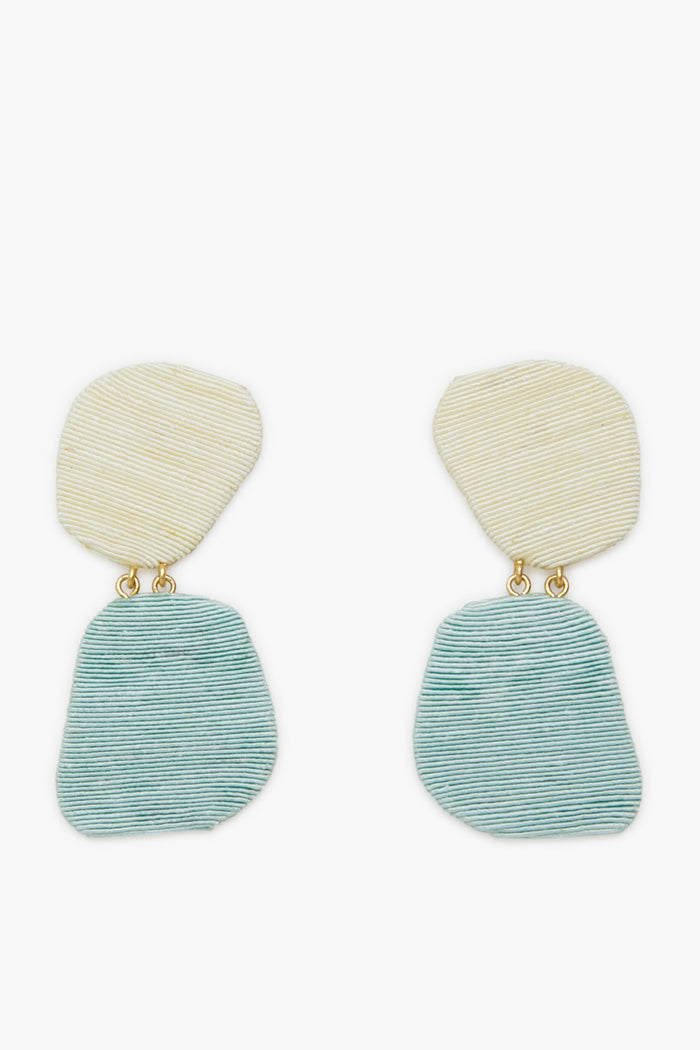 Tuckernuck Jewelry’s Ula Earrings feature irregular, textured ovals—off-white on top, light blue below—joined by small gold links. Lightweight and hypoallergenic, they provide comfort and a modern look.
