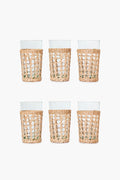 The Seagrass set includes six clear glass tumblers in woven rattan sleeves, arranged in two rows of three—a stylish glassware set that brings coastal charm to any space.