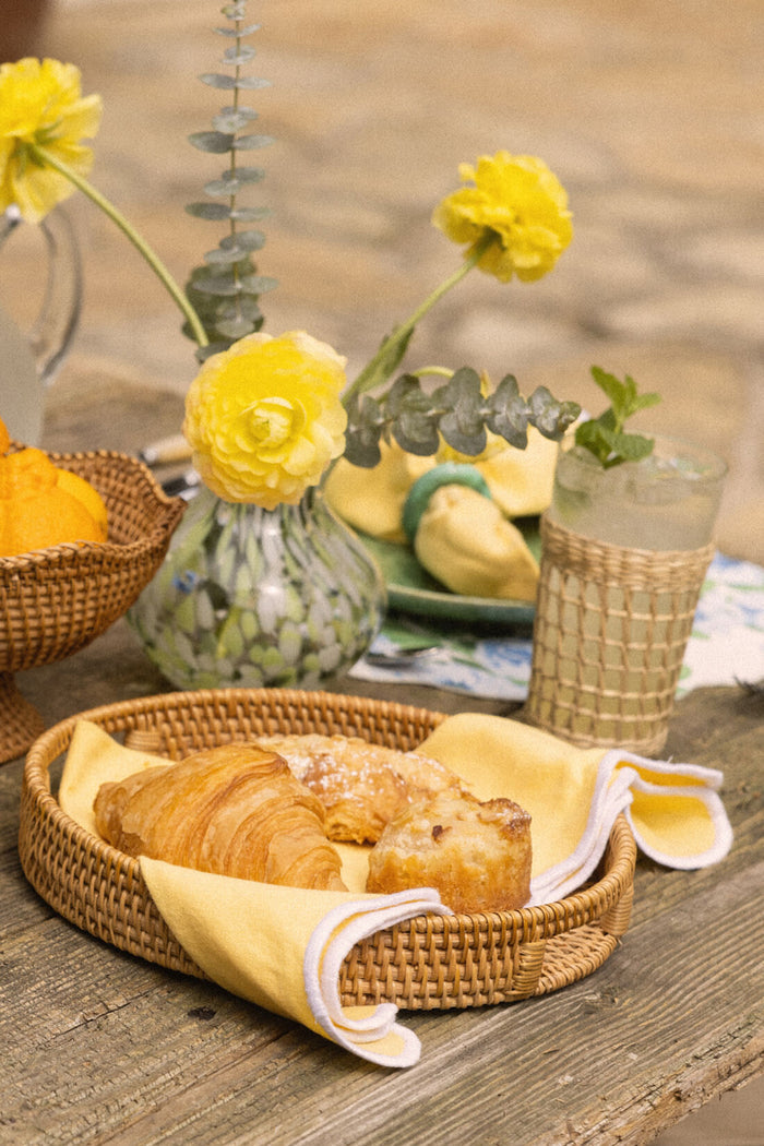 Seagrass Cage Highball Set of 6 displayed in a rustic outdoor setting, featuring classic woven glassware, effortlessly enhancing a fun and high-end picnic or breakfast scene.