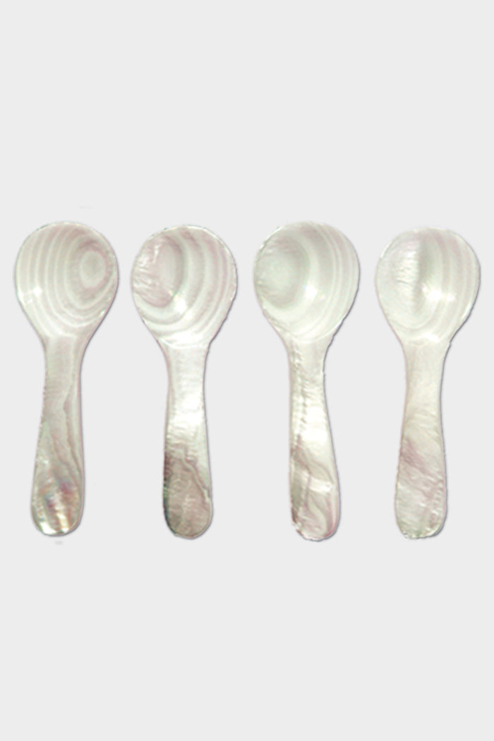 Four white plastic spoons by Be Home, featuring a marbled pattern inspired by Mother of Pearl, are arranged vertically in a row.