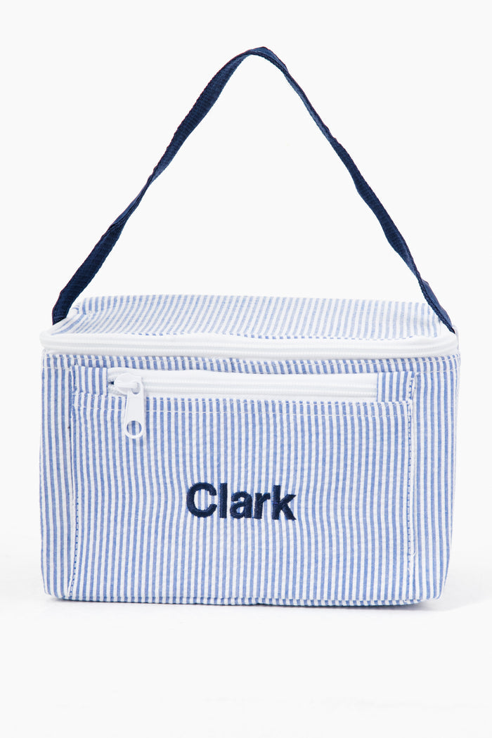 A rectangular Caton's Wharf Seersucker Lunch Box in blue and white stripes, with a navy handle, front zipper pocket, and "Clark" embroidered on the front.