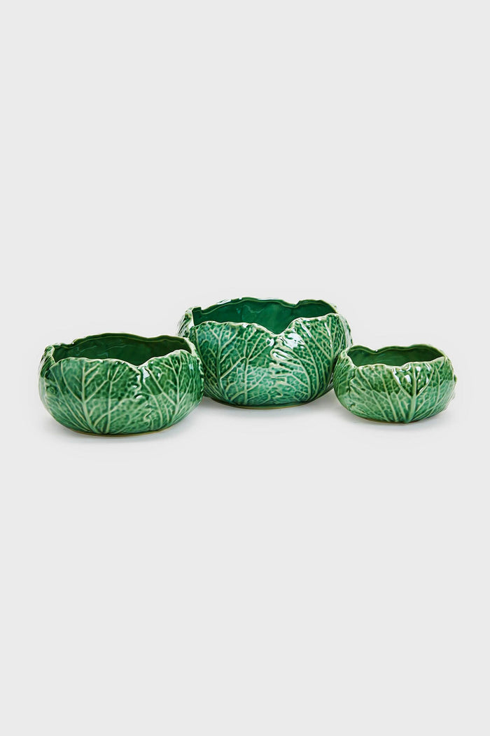 Three green ceramic cabbage bowls from Two's Company, shaped and textured like cabbage leaves, are arranged in a row—ideal as decorative serving bowls for an organic farmers market vibe.