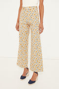 Wearing Emerson Fry high-rise, wide-leg yellow and blue floral print stretch cotton twill pants, a sleeveless white top, and navy espadrille wedge shoes.