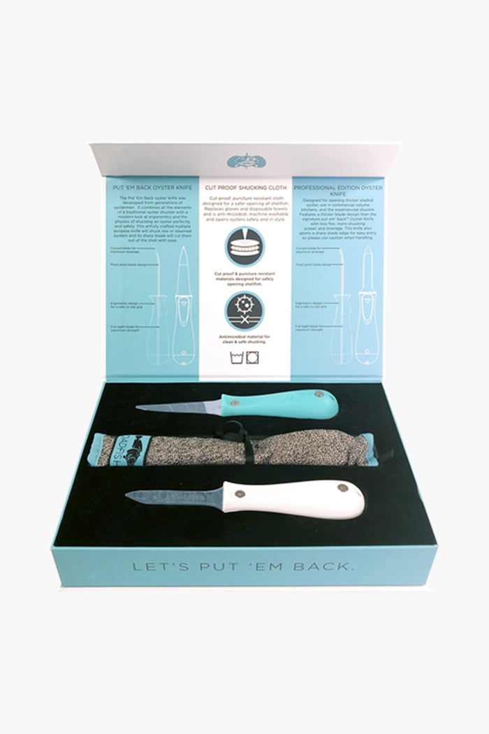 An open Toadfish box displays oyster shucking tools: two oyster knives, a protective glove, and an instructional guide with diagrams and text on the inside lid.