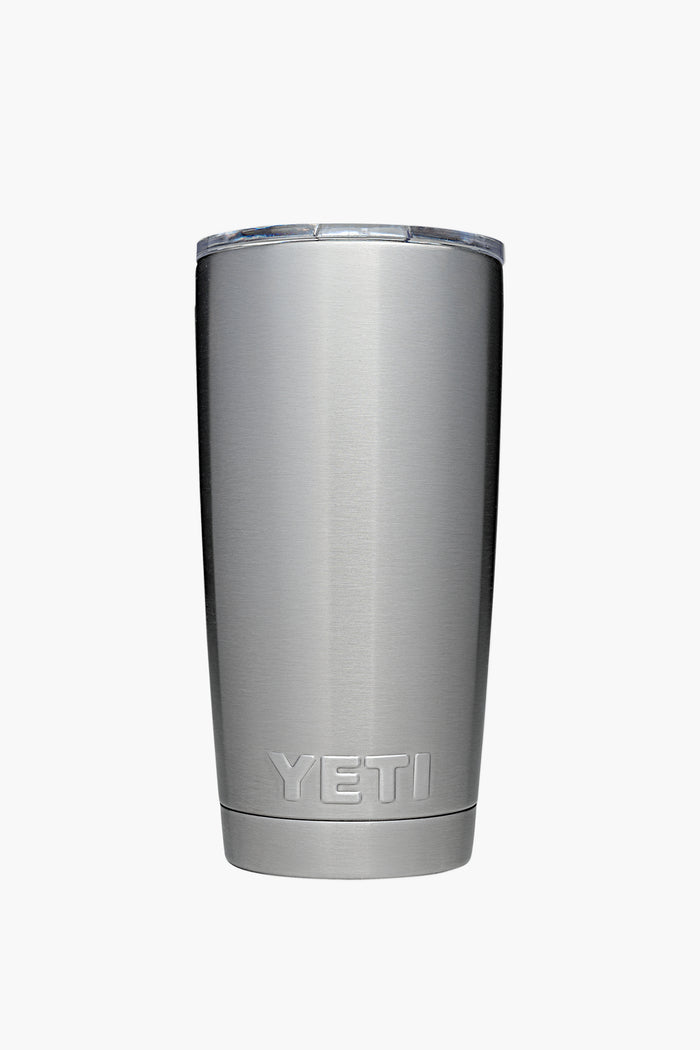 A YETI stainless steel tumbler with double-wall vacuum insulation and a transparent lid, shown standing upright.