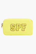The Stoney Clover Lane rectangular yellow toiletry bag features a zipper and glittery gold-outlined SPF letters on the front—ideal for carrying your travel accessories.