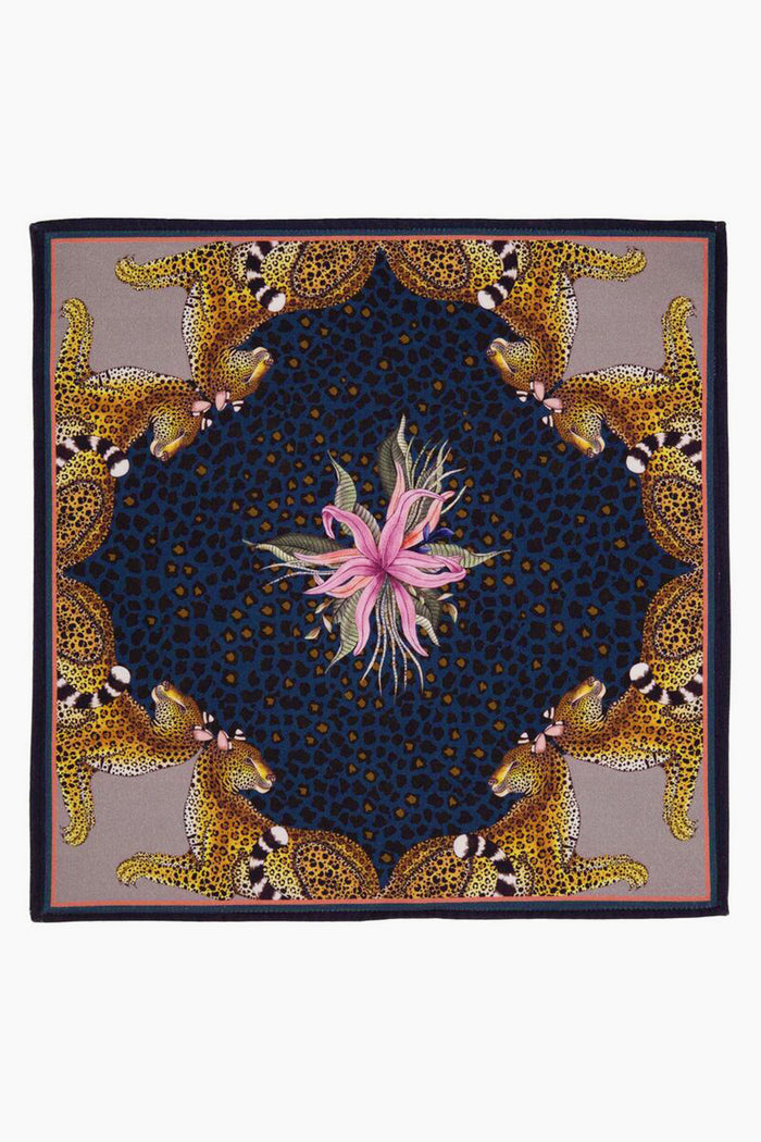 A square scarf by Ardmore Design featuring a central pink flower, a dark blue and black jungle motif, and four cheetahs in the corners, inspired by South African design.