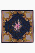 A square scarf by Ardmore Design featuring a central pink flower, a dark blue and black jungle motif, and four cheetahs in the corners, inspired by South African design.