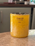 Yellow cylindrical container labeled 'Rouge 540' on a wooden surface.