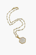 ASHA gold chain necklace featuring small beads and a flower-shaped white enamel mother of pearl pendant with an intricate pattern.