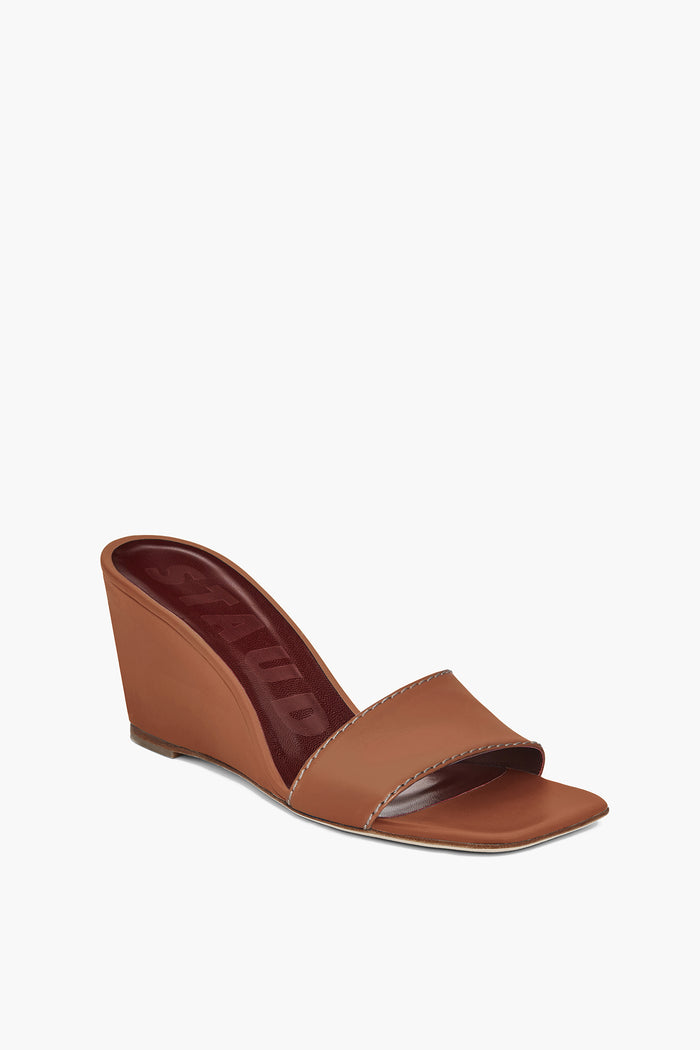 The STAUD Billie Wedge sandal features a tan open-toe design with a single wide strap, maroon insole, and stylish brown leather heels.