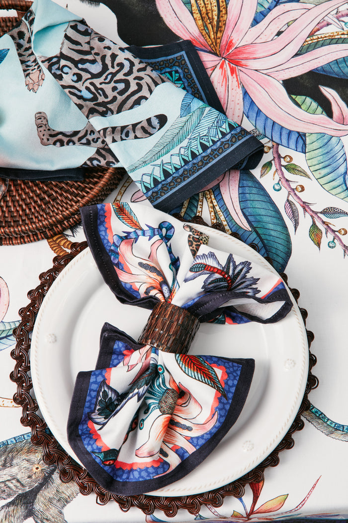 Tabletop display featuring the Tanzanite Cheetah Kings Tea Towel with regal cheetahs, blending classic style and effortless fun amidst high-end, vibrant table settings.