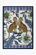 Illustration of two leopards sitting back to back among blue leaves, flowers, and decorative borders. Inspired by Ardmore Design, this pattern is perfect for a leopard tea towel or cotton kitchen accessory.