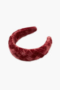 A quilted, deep red padded velvet headband by Loeffler Randall is shown.