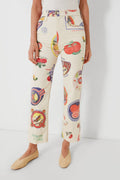 A person wearing MOTHER cream-colored high-waisted jeans featuring a vibrant fruit sticker print, visible from waist to ankles.