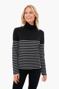 A woman smiles in a KULE striped turtleneck with white horizontal stripes, layered over a black tissue cotton tee.