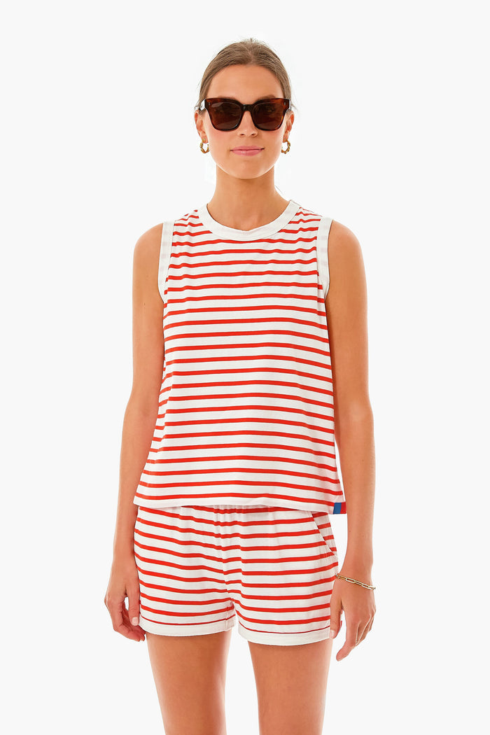 A woman wearing KULE sunglasses and a red-and-white striped tank with matching shorts stands confidently, showcasing the brand's summer sleeveless top.