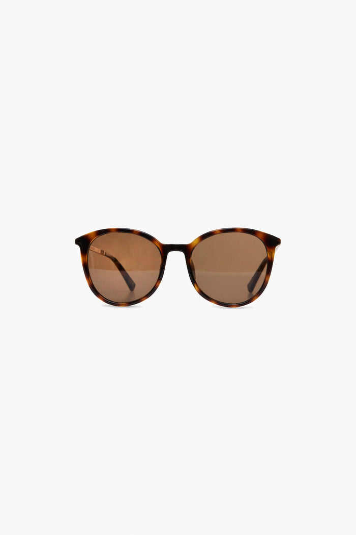 A pair of Le Specs sunglasses with brown tortoise frames, round polarized lenses, and thin arms.