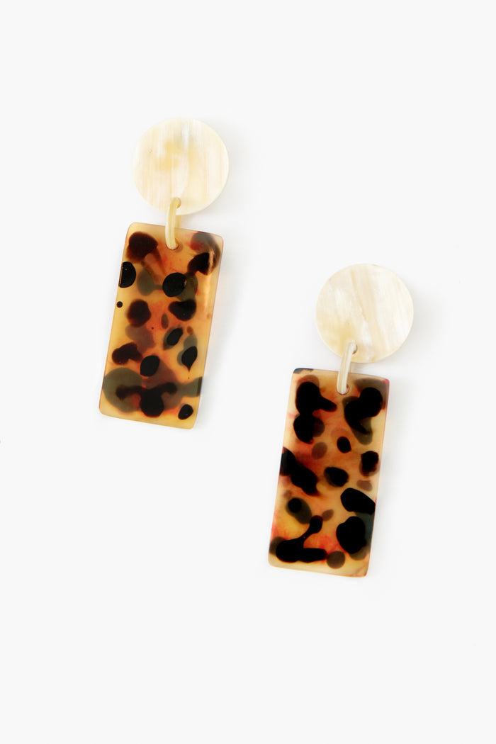 Sunshine Tienda earrings featuring round cream-colored studs and rectangular, hand-painted tortoiseshell-patterned dangles—a unique jewelry piece.