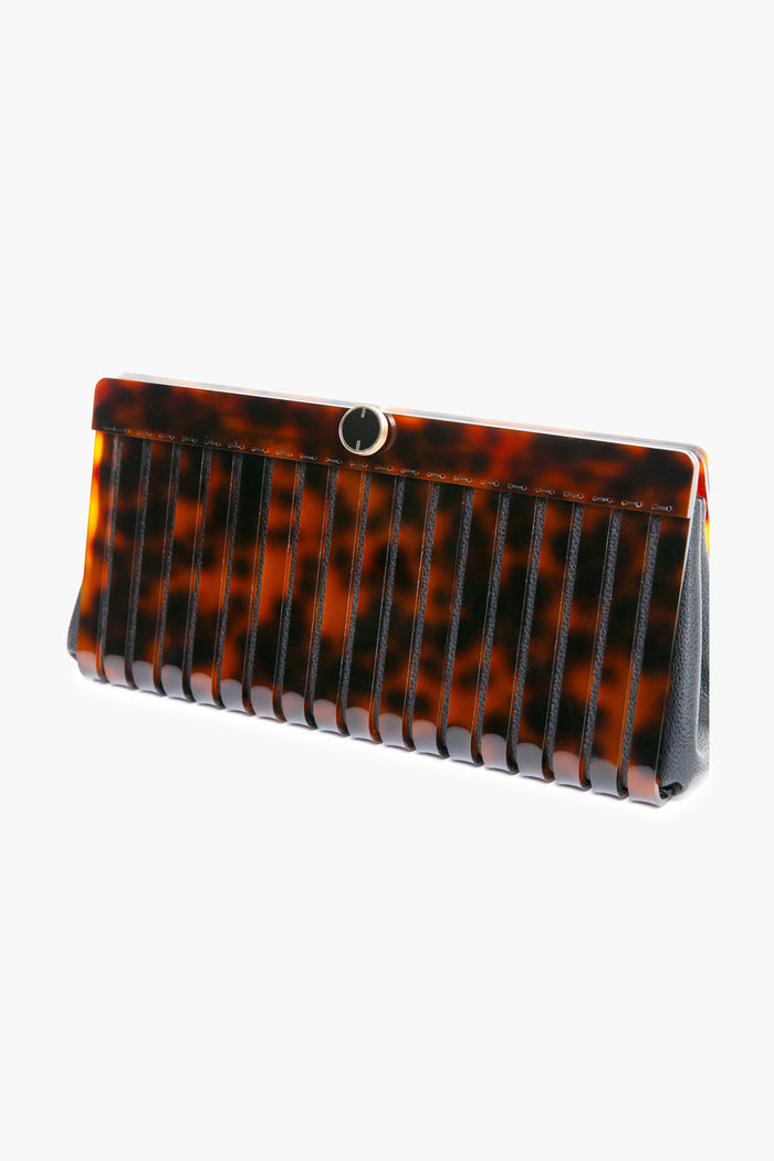 Cult Gaia rectangular faux tortoise clutch featuring a glossy tortoiseshell pattern, vertical black stripes, and a small round metal clasp at the top.