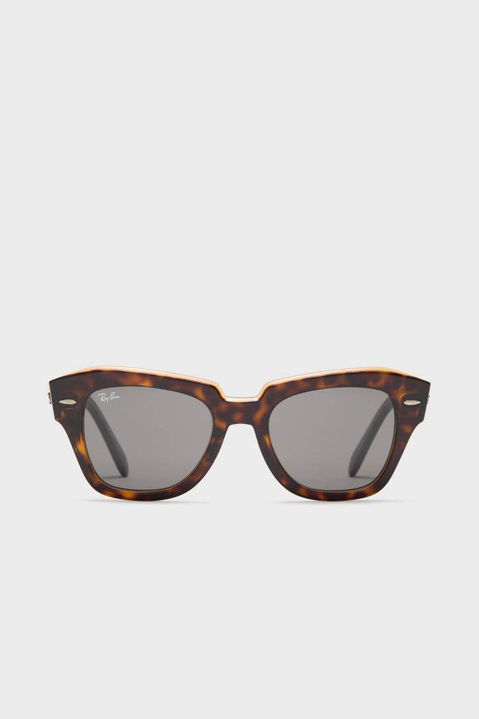 Ray-Ban tortoise shell sunglasses featuring a rectangular frame and dark lenses, inspired by the classic Wayfarer design.